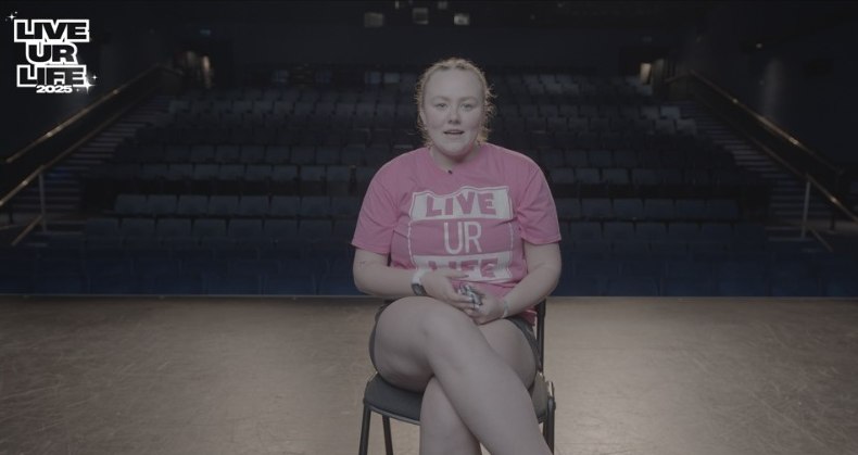Interview subject on a theatre stage before colour grading